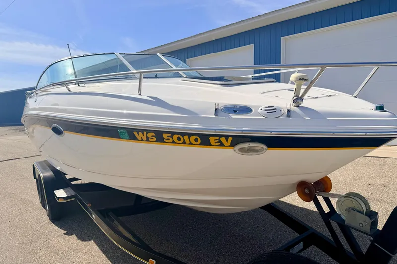 Slide: The Image of 2000 Chaparral 235 SSi boat on trailer, parked outdoors near blue building. - 7