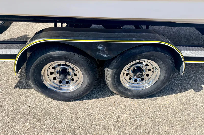 Slide: The Image of Trailer wheels of a 2000 Chaparral 235 SSi boat on pavement. - 71