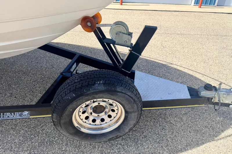 Slide: The Image of Trailer for 2000 Chaparral 235 SSi boat on pavement, featuring wheel and hitch. - 72