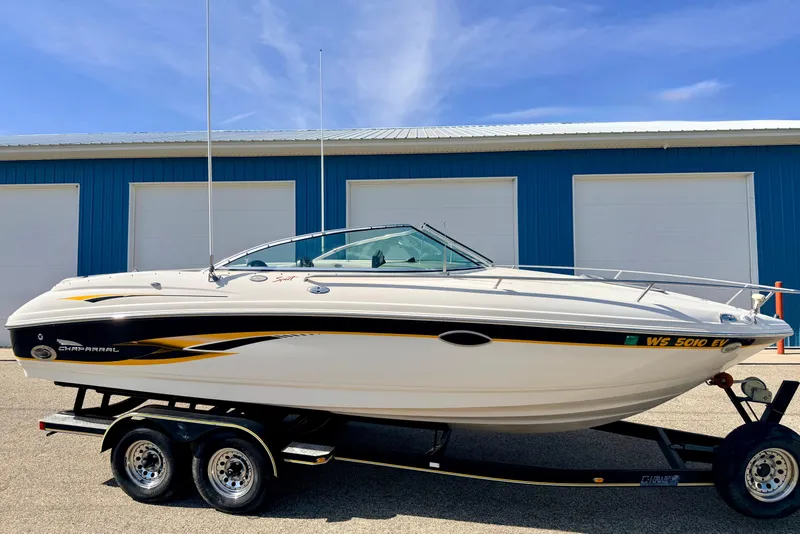 Slide: The Image of 2000 Chaparral 235 SSi boat on trailer, parked near blue storage units. - 76