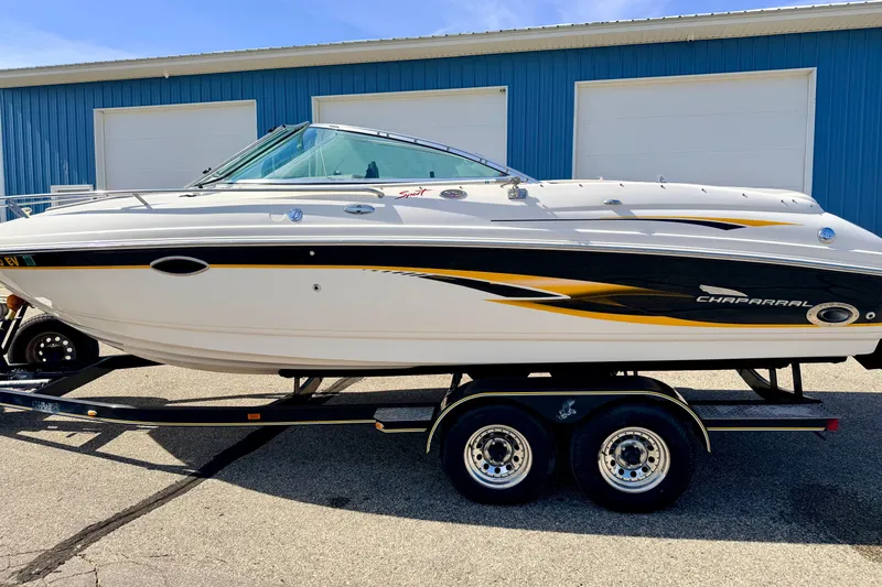 Slide: The Image of 2000 Chaparral 235 SSi boat on trailer, parked outside blue building. - 79