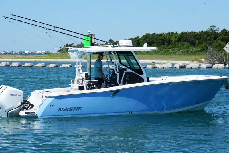 Slide: The Image of 2024 Blackfin 272 CC boat cruising on a sunny day with fishing rods. - 5
