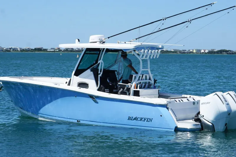 Slide: The Image of 2024 Blackfin 272 CC boat on water, featuring dual Mercury engines and fishing rods. - 7