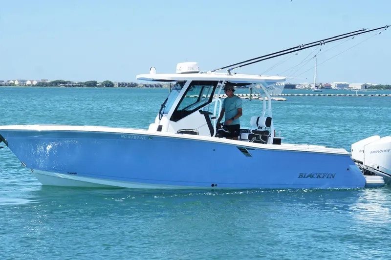 Slide: The Image of 2024 Blackfin 272 CC boat cruising on clear blue water. - 9