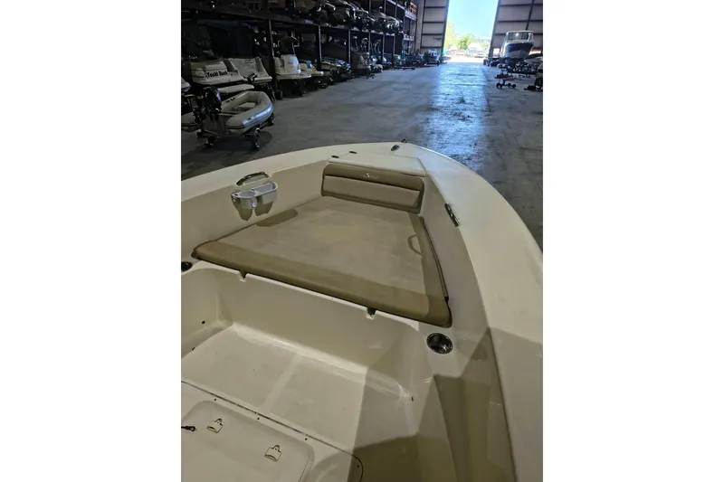 Slide: The Image of 2020 Scout 195 Sportfish boat interior with seating, stored in a spacious warehouse. - 13