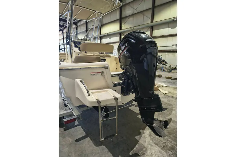Slide: The Image of 2020 Scout 195 Sportfish boat with Mercury outboard motor in a warehouse setting. - 4