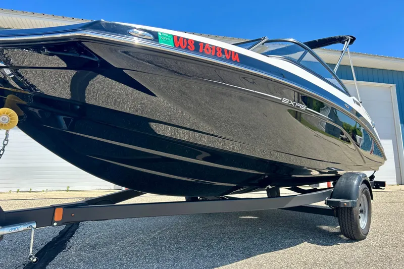 Slide: The Image of 2024 Yamaha Boats SX195 on trailer, sleek black design, parked outdoors. - 10