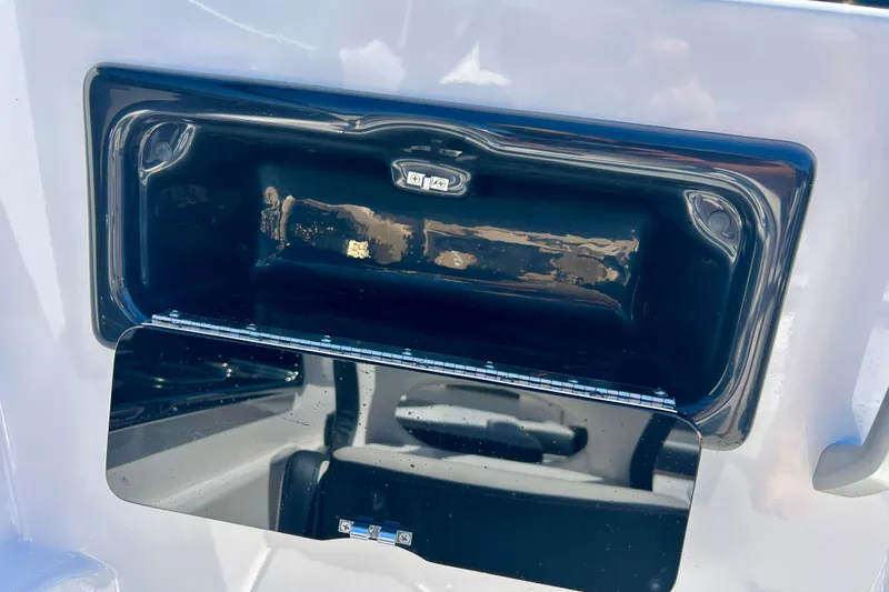 Slide: The Image of 2024 Yamaha Boats SX195 storage compartment detail with sleek black finish. - 20