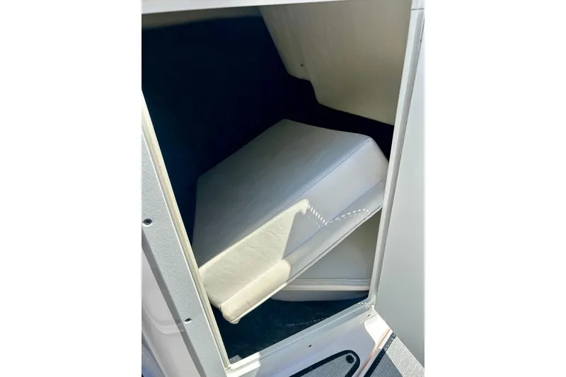 Slide: The Image of 2024 Yamaha Boats SX195 interior storage compartment with cushioned seating. - 22