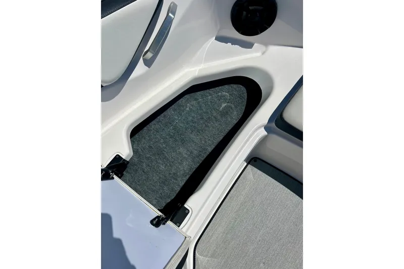 Slide: The Image of 2024 Yamaha Boats SX195 interior storage compartment with carpeted lining. - 25