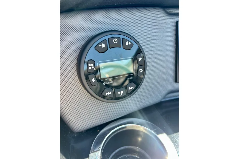 Slide: The Image of 2024 Yamaha Boats SX195 dashboard with Bluetooth audio controls and cup holder. - 37