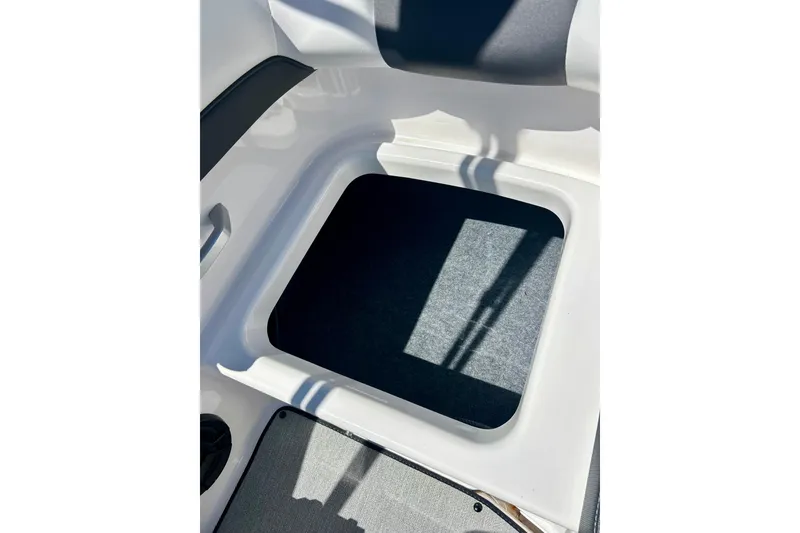 Slide: The Image of 2024 Yamaha SX195 boat storage compartment with carpeted interior. - 44