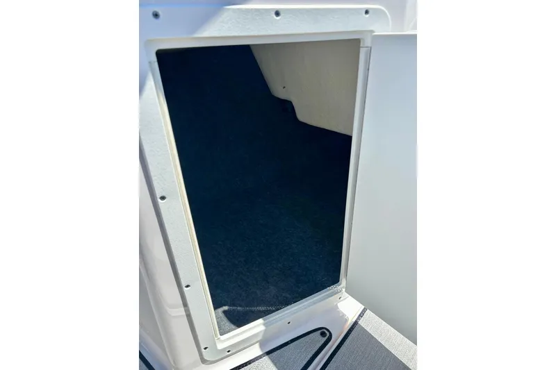 Slide: The Image of 2024 Yamaha Boats SX195 storage compartment with open hatch, showcasing interior space. - 50
