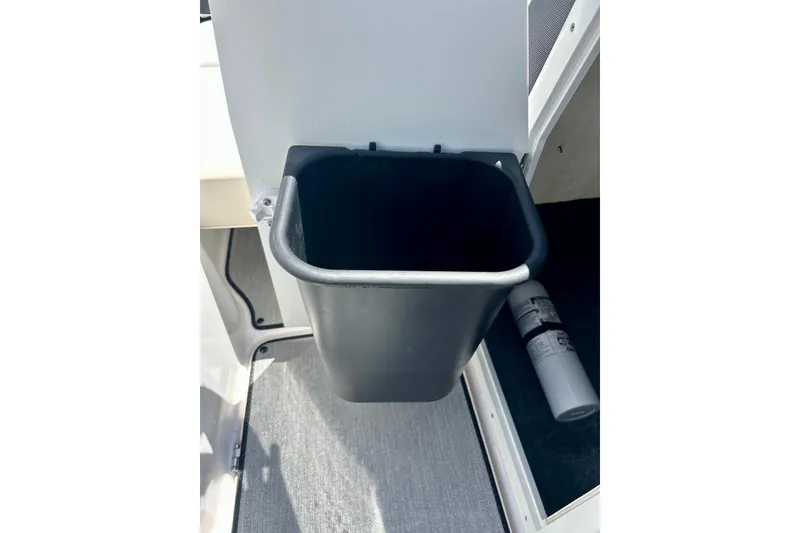 Slide: The Image of 2024 Yamaha Boats SX195 interior with built-in trash bin and fire extinguisher. - 52