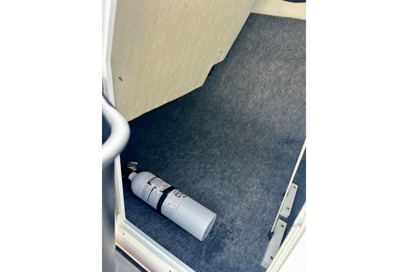 Slide: The Image of 2024 Yamaha Boats SX195 interior with fire extinguisher on carpeted floor. - 53