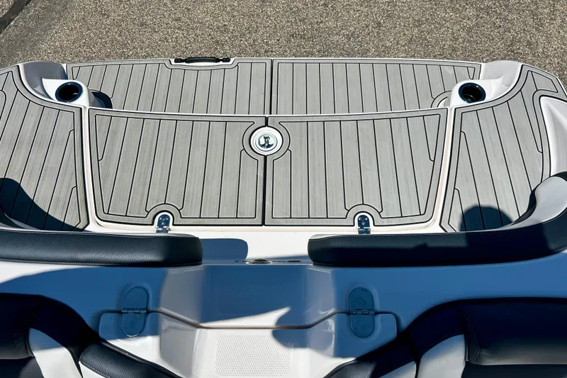 Slide: The Image of 2024 Yamaha Boats SX195 swim platform with sleek gray decking and cup holders. - 55
