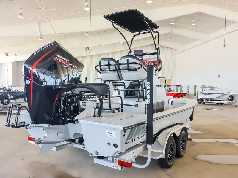 Slide: The Image of The image shows a 2026 Majek M2 Illusion boat in a showroom. It features a powerful outboard motor and elevated helm console. - 6