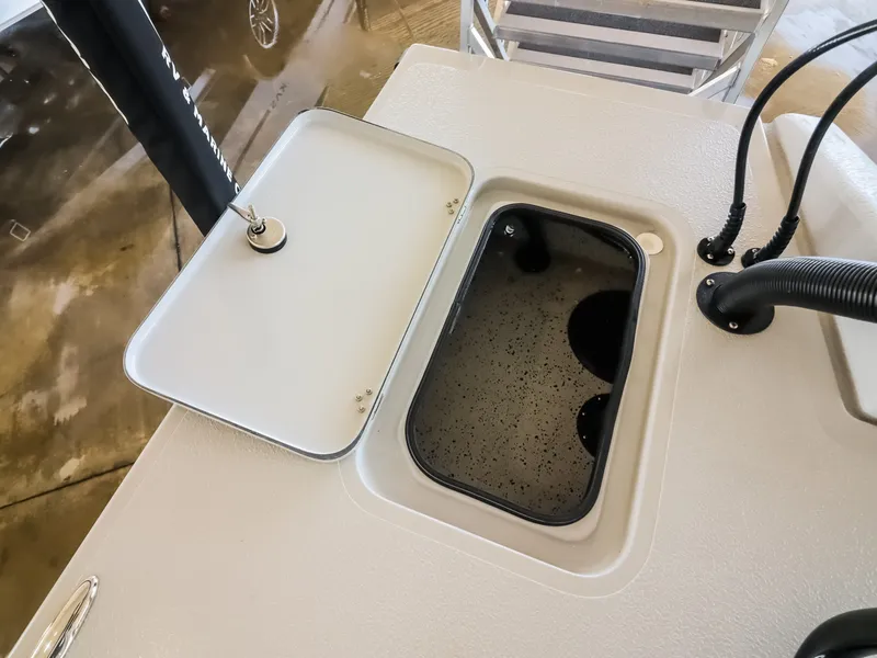 Slide: The Image of An open compartment on a boat with a black lid and a cable. - 20