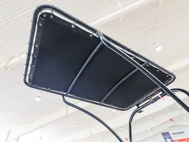 Slide: The Image of The image shows the black T-top of a Majek M2 Illusion boat in a showroom. - 16