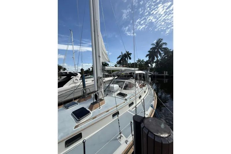 Slide: The Image of 1986 Little Harbor LH46 sailboat docked under a clear blue sky with palm trees. - 12
