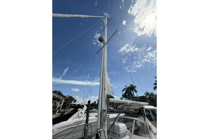 Slide: The Image of 1986 Little Harbor LH46 sailboat mast against a clear blue sky with scattered clouds. - 13