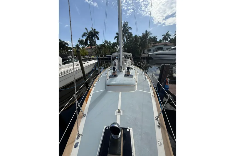 Slide: The Image of 1986 Little Harbor LH46 sailboat docked, surrounded by palm trees and other boats. - 15