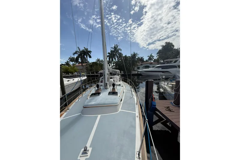 Slide: The Image of 1986 Little Harbor LH46 sailboat docked, surrounded by palm trees and other boats. - 16