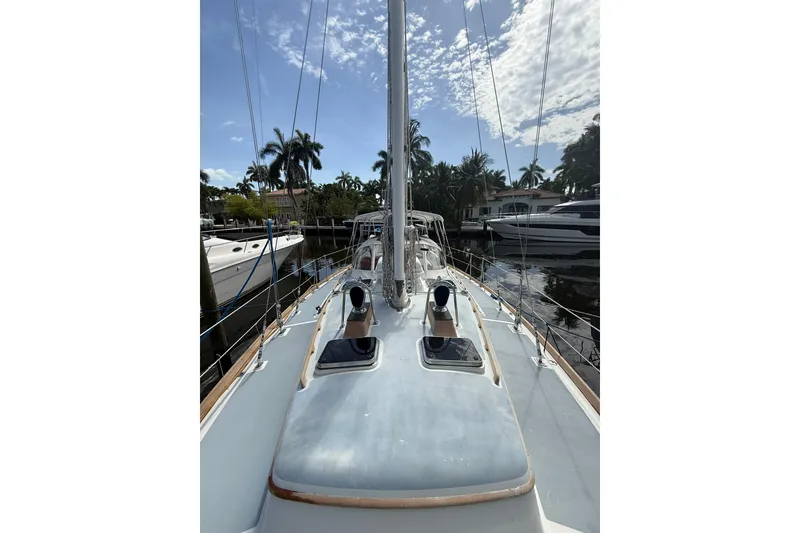 Slide: The Image of 1986 Little Harbor LH46 sailboat docked, showcasing deck and rigging under a partly cloudy sky. - 18