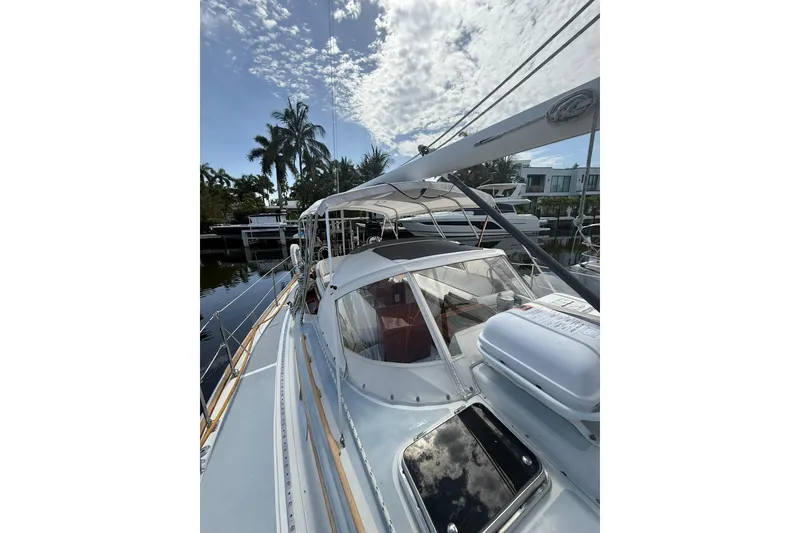 Slide: The Image of 1986 Little Harbor LH46 yacht docked, featuring sleek design and spacious deck under a partly cloudy sky. - 21
