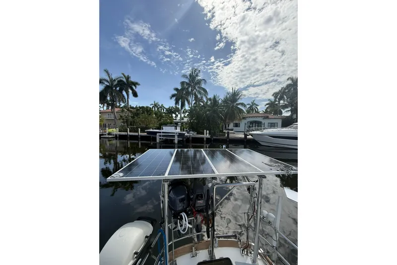 Slide: The Image of 1986 Little Harbor LH46 yacht with solar panels, docked near palm trees and waterfront homes. - 28
