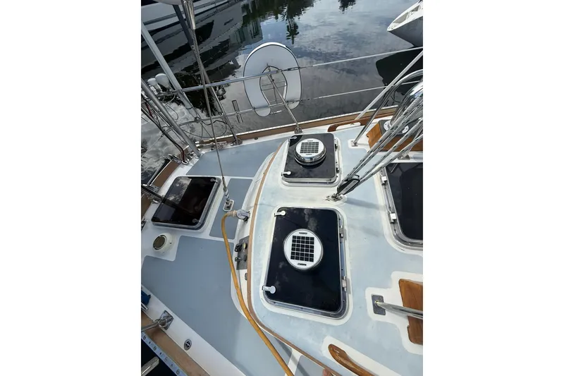 Slide: The Image of 1986 Little Harbor LH46 yacht deck with solar vents and hatches, docked by calm water. - 29