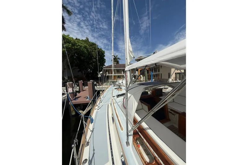 Slide: The Image of 1986 Little Harbor LH46 sailboat docked, showcasing deck and rigging under a clear blue sky. - 34