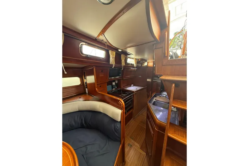 Slide: The Image of Interior of 1986 Little Harbor LH46 yacht, featuring wooden cabinetry and cozy seating area. - 47