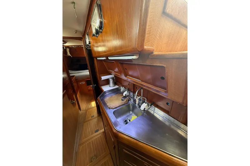 Slide: The Image of Interior of 1986 Little Harbor LH46 yacht featuring a compact wooden galley with stainless steel sink. - 50