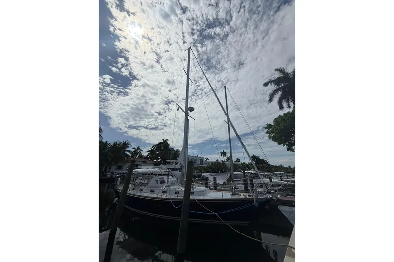 Slide: The Image of Sailboat Little Harbor LH46, 1986 model, docked under a cloudy sky with palm trees. - 6