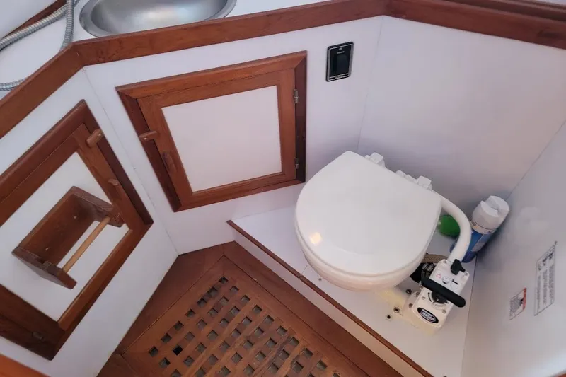 Slide: The Image of 1987 Albin 37 Palm Beach yacht bathroom with wooden cabinetry and marine toilet. - 10
