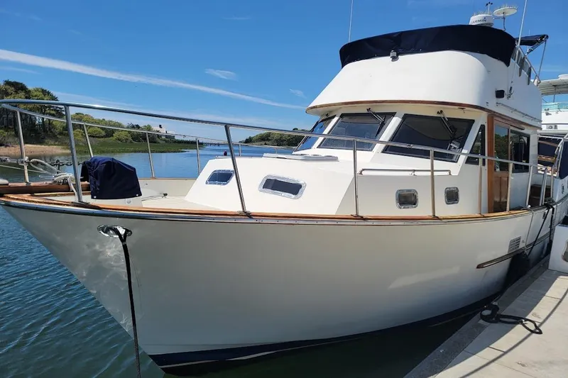 Slide: The Image of 1987 Albin 37 Palm Beach yacht docked by a scenic waterway. - 14