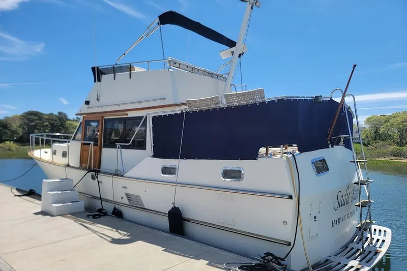 Slide: The Image of 1987 Albin 37 Palm Beach yacht docked, featuring a spacious deck and canopy. - 2