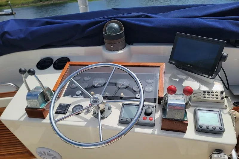 Slide: The Image of Control panel of a 1987 Albin 37 Palm Beach boat with steering wheel and navigation instruments. - 22