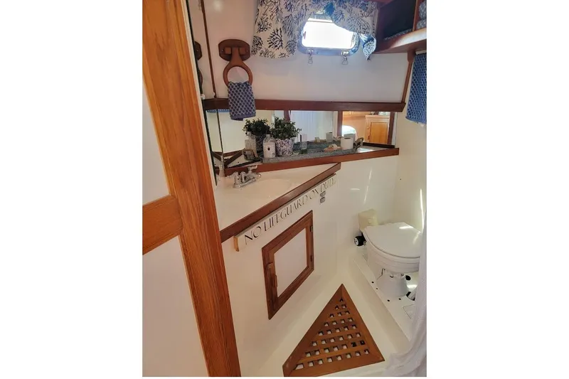 Slide: The Image of 1987 Albin 37 Palm Beach yacht bathroom with wooden accents and nautical decor. - 27