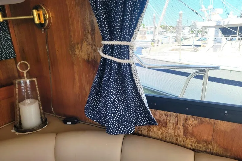Slide: The Image of Interior of 1987 Albin 37 Palm Beach boat with blue curtains and candle. - 30