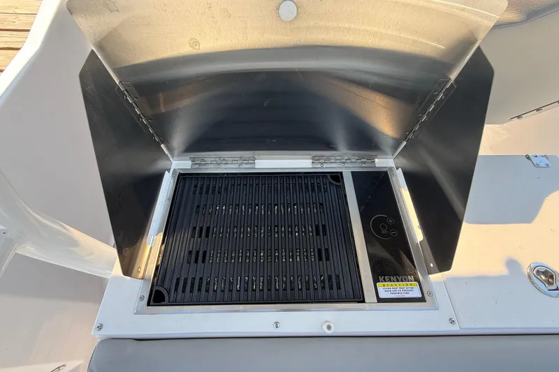 Slide: The Image of Built-in grill on 2024 Solara S-250 CW boat, featuring Kenyon electric cooktop. - 15