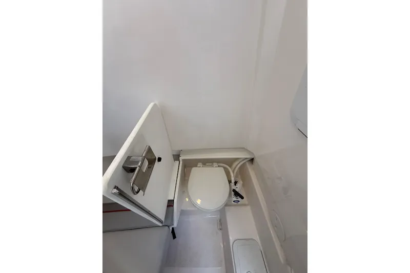 Slide: The Image of Compact bathroom in 2024 Solara S-250 CW boat, featuring a modern toilet and storage compartment. - 32