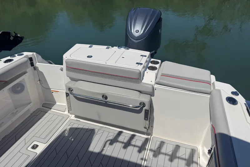 Slide: The Image of 2024 Solara S-250 CW boat interior with seating and motor, docked on calm water. - 5