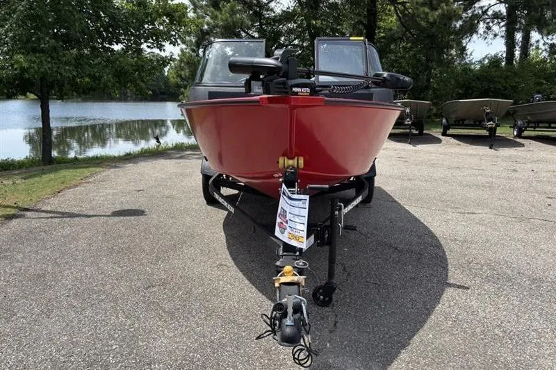 Slide: The Image of 2026 Tracker Pro Guide V-16 WT boat on trailer by a lake. - 2