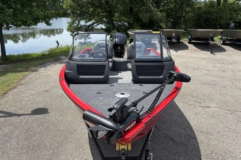 Slide: The Image of 2026 Tracker Pro Guide V-16 WT boat with dual windshields, parked near a lake. - 3