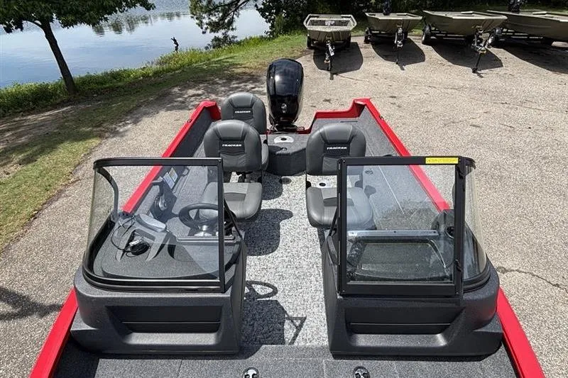Slide: The Image of 2026 Tracker Pro Guide V-16 WT boat with dual consoles and seating, parked near a lake. - 4