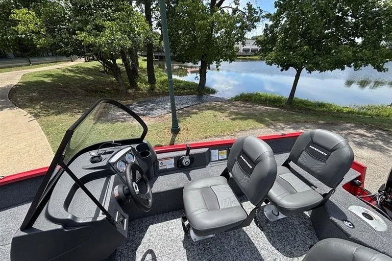 Slide: The Image of 2026 Tracker Pro Guide V-16 WT boat interior with seating, near a scenic lake. - 5