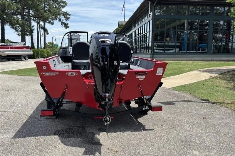 Slide: The Image of 2026 Tracker Pro Guide V-16 WT boat, red exterior, parked outdoors near a building. - 8