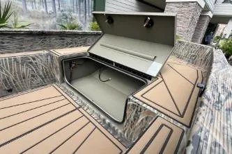 Slide: The Image of 2026 Tracker Grizzly 1650 T Prairie Wings Edition boat with open storage compartment. - 6
